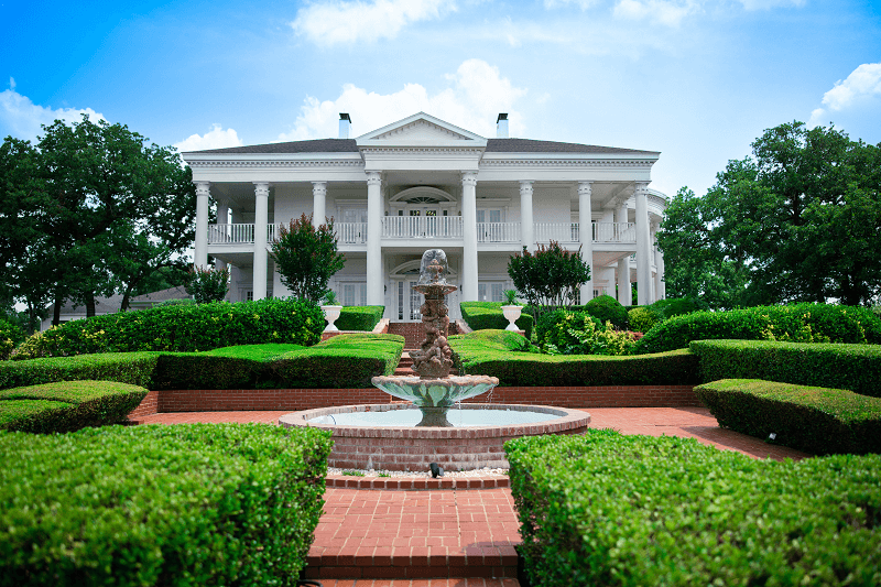 the front of the mansion with the fountain