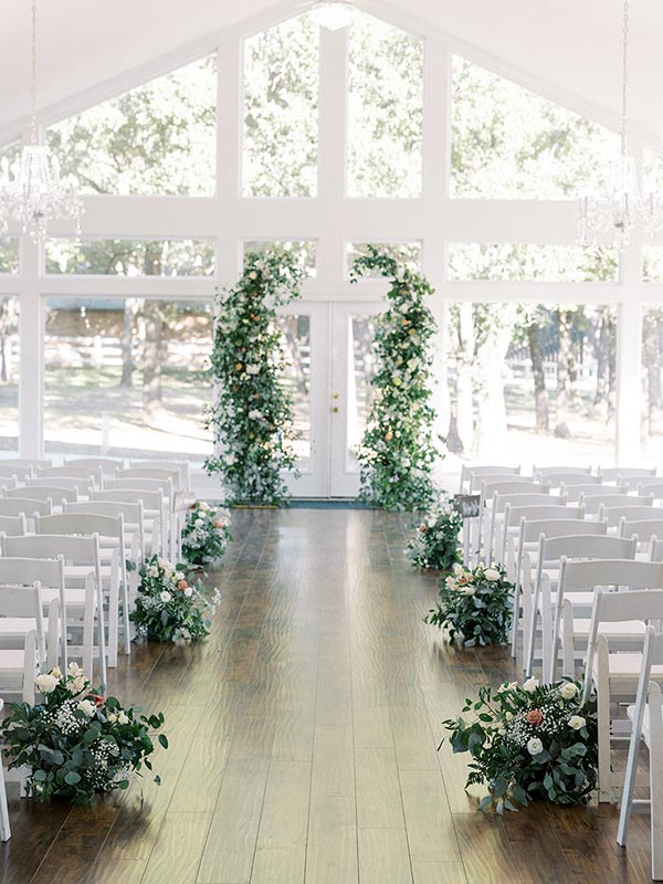 lone star mansion ballroom aisle lined with flowers and greenery