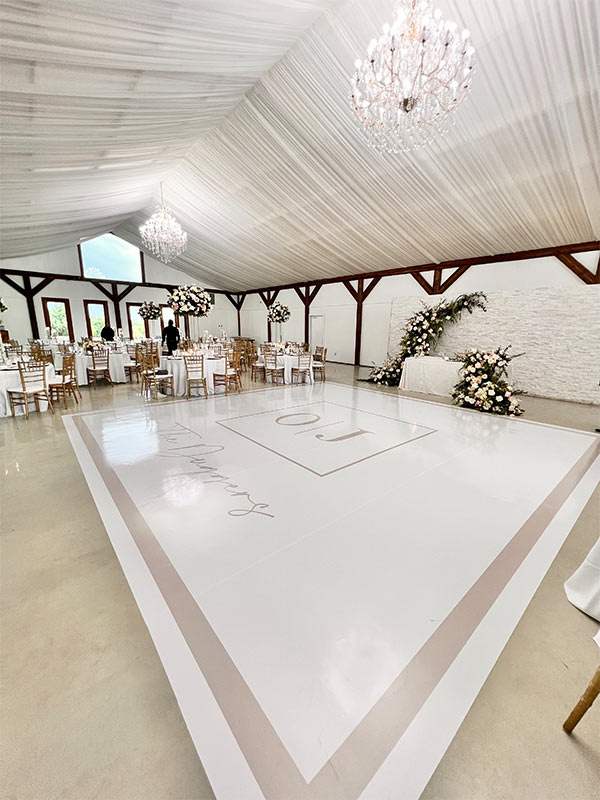 a big open ballroom with a customized floor of the bride and groom initials