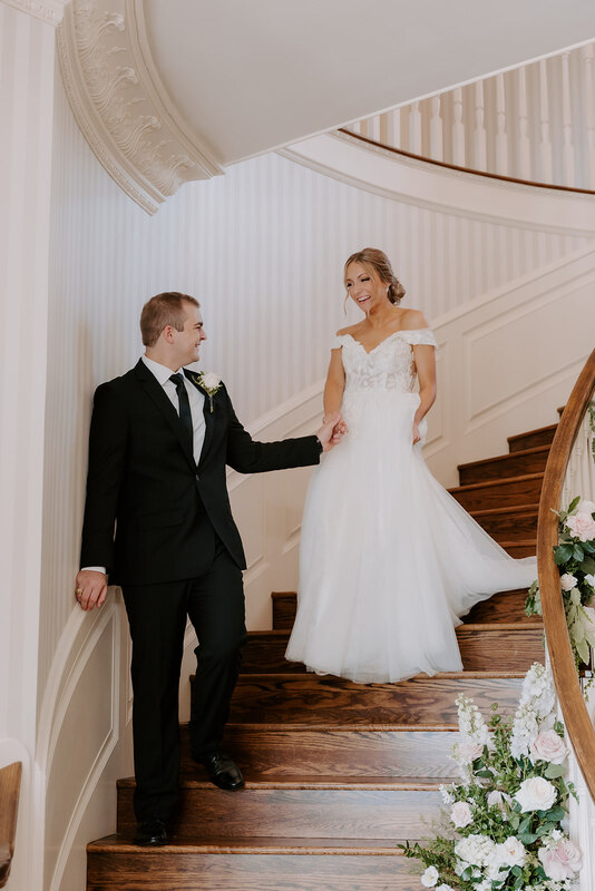 bride and groom walking down a stair case together