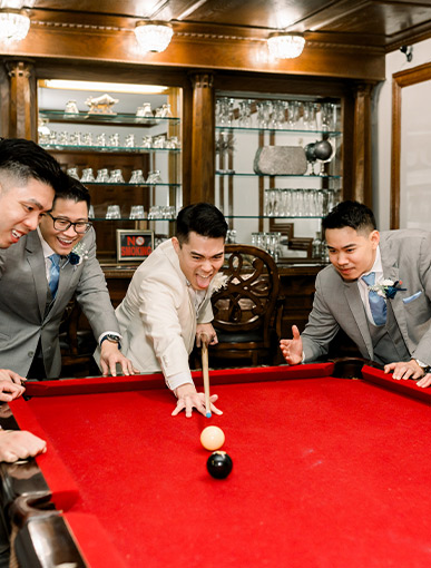 groomsmen playing pool inside the mansion