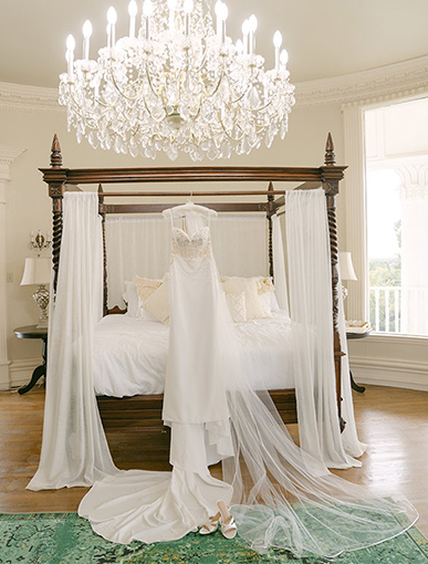 bridal gown hanging on the bed in the bridal suite