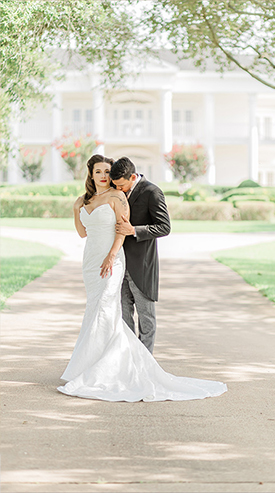 a bride and groom in front of the Lone Star Mansion