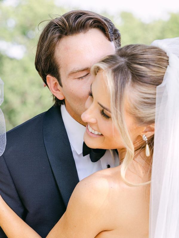 A groom kissing his beautiful bride. 